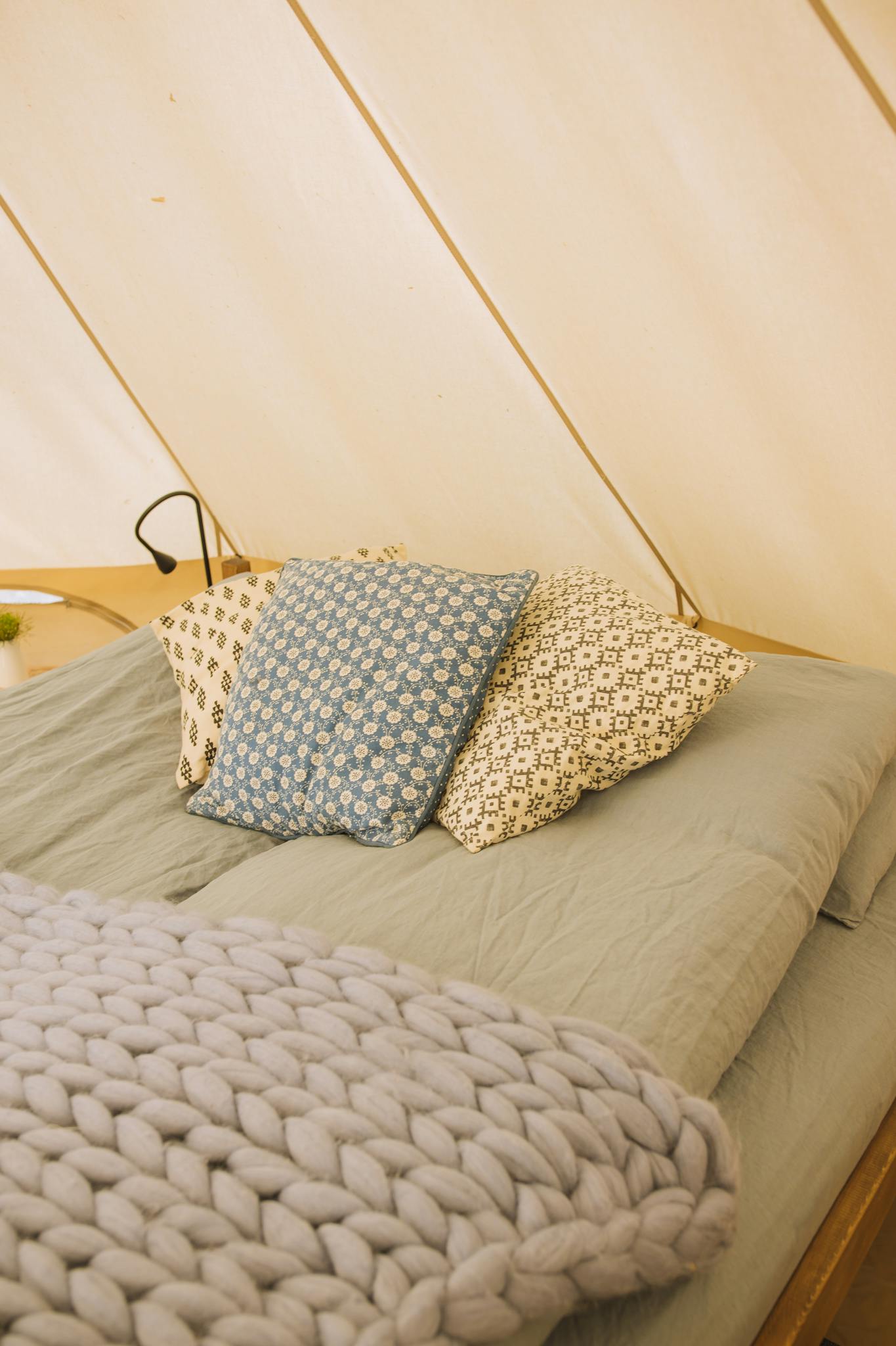 Comfortable bedding setup featuring a soft blanket and patterned pillows.
