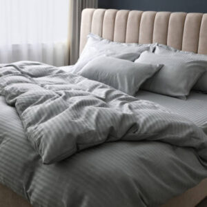 Comfortable bed with soft blanket and pillows indoors