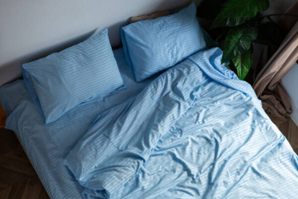 A messy minimal bedroom with an unmade bed